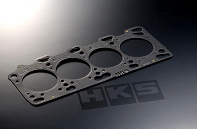 A black HKS 87-92 Supra MK3 2.0mm Stopper Headgasket, displayed on a dark background with the HKS logo visible.